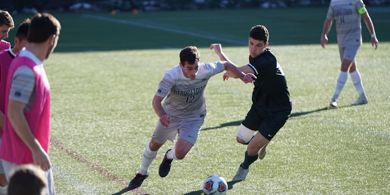 年轻足球运动员训练场景 - 身穿训练服的球员在绿茵场上进行传球练习